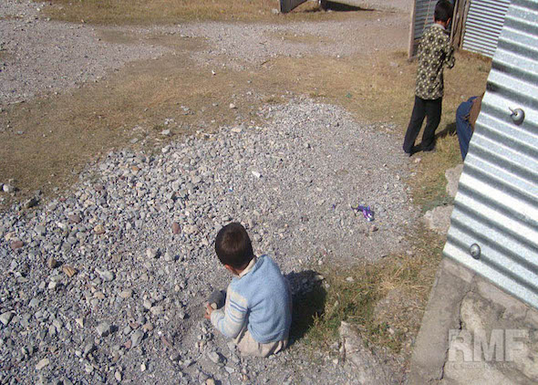 young boy playing in the gravel